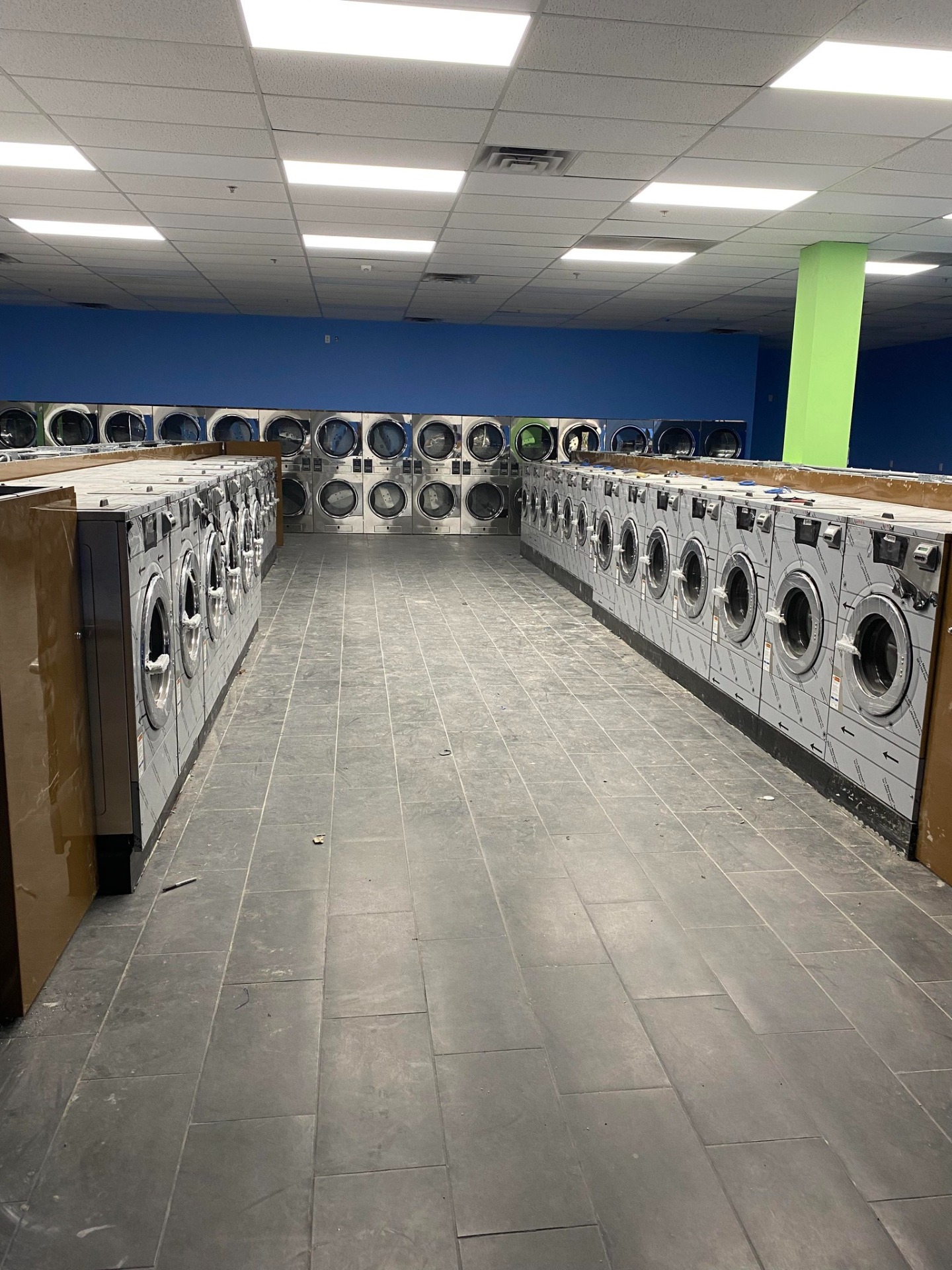 Laundromat aisle with washers and stacked dryers